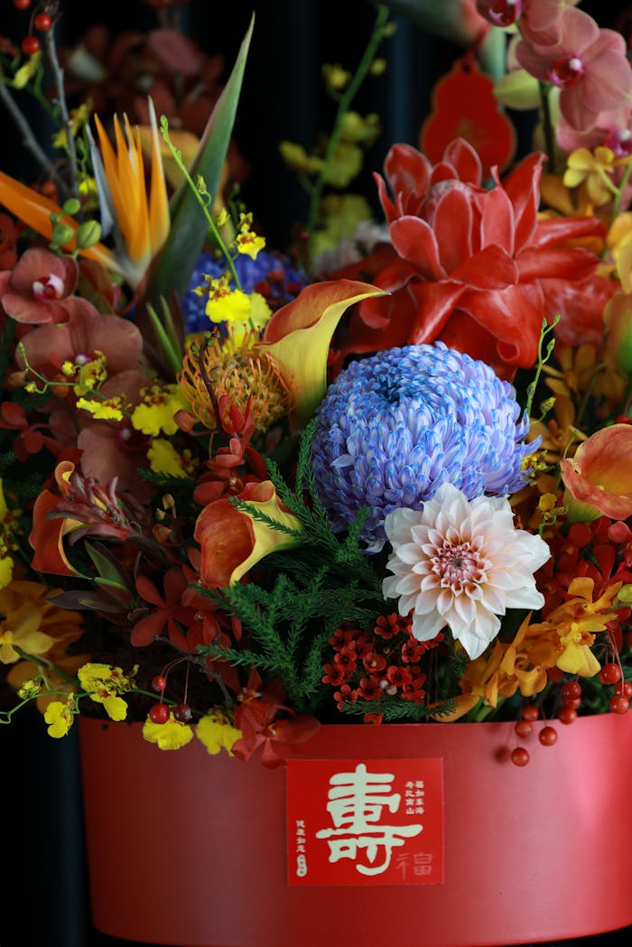 heros-img Colorful floral display with diverse blooms in a red vase, ideal for celebrations.