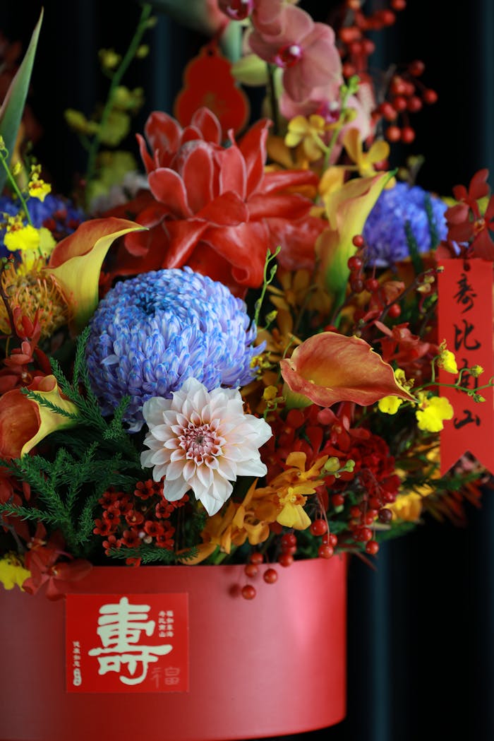 Vibrant floral arrangement with diverse flowers in decorative pot.